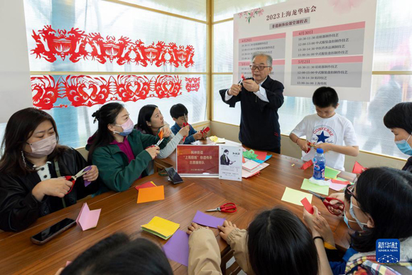 4月29日，人们在龙华庙会上体验剪纸课程。
