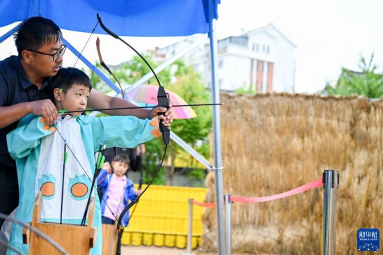 6月22日，游客在位于吉林省延边朝鲜族自治州延吉市的中国朝鲜族民俗园体验射箭。新华社记者 颜麟蕴 摄