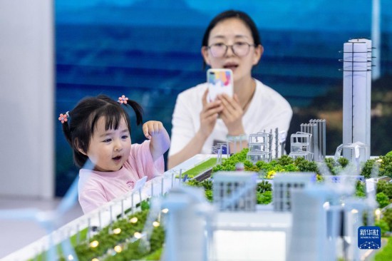 8月19日，在第七届中国—南亚博览会云南能投展区，一名家长带着孩子参观展览。