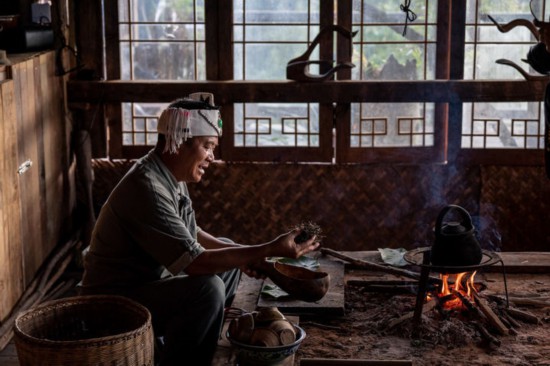 在景迈山芒景村，布朗族茶农南康在火塘边做烤茶（9月14日摄）。新华社记者 胡超 摄