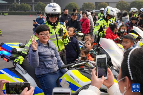 1月6日，在警营开放周活动现场，小朋友体验警用摩托车并与交警合影。