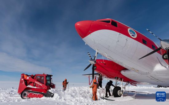 2月6日，暴风雪后，中国第40次南极考察队员为“雪鹰601”清理积雪。新华社发（裴文悦摄）